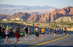 Runners descending through red rock formations at the St. George Marathon